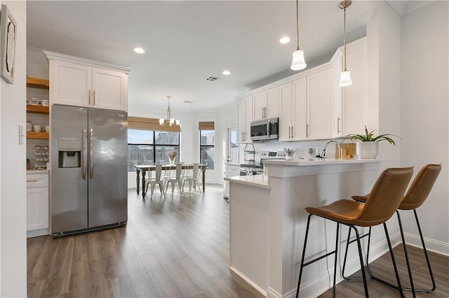 kitchen featuring white cabinets, tasteful backsplash, stainless steel appliances, and light countertops