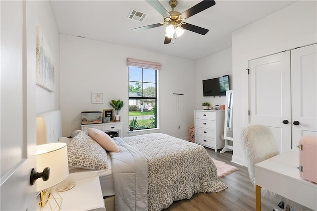 bedroom featuring a ceiling fan, a closet, visible vents, and wood finished floors