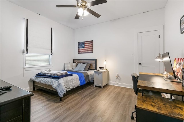 bedroom featuring light wood-style flooring, baseboards, and ceiling fan