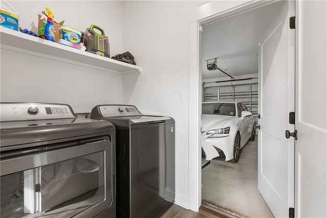 laundry room with a garage, washer and dryer, and laundry area