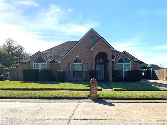 view of front facade with a front yard, brick siding, and fence