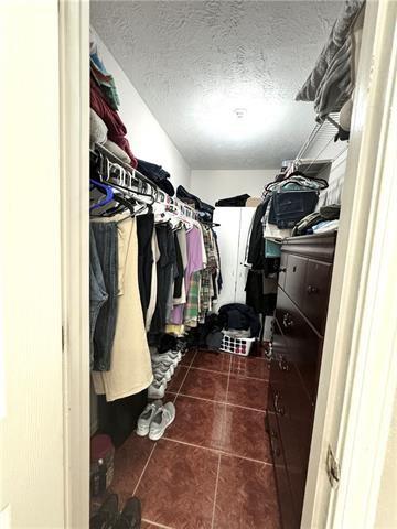 spacious closet featuring dark tile patterned floors