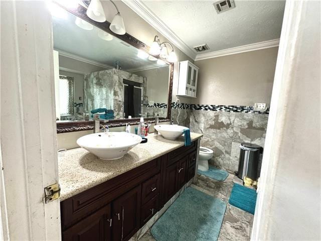 full bath with visible vents, a sink, tile walls, and double vanity