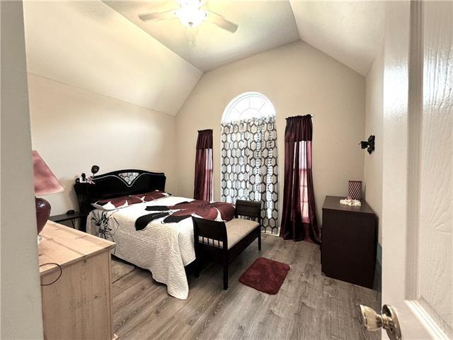 bedroom with light wood finished floors, ceiling fan, and vaulted ceiling