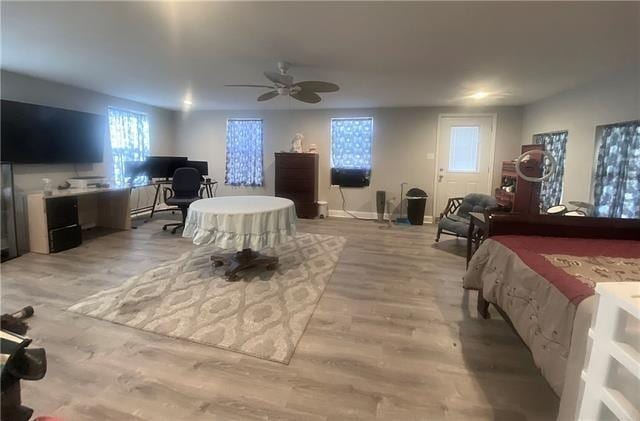 bedroom featuring light wood-type flooring, baseboards, and a ceiling fan