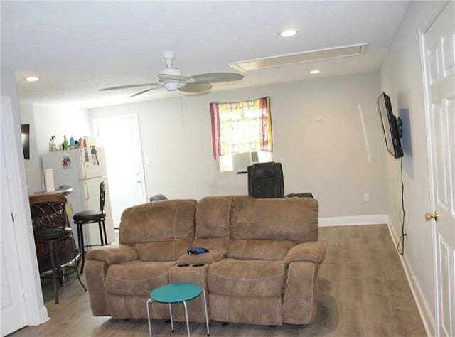 living room featuring a ceiling fan, recessed lighting, baseboards, and wood finished floors