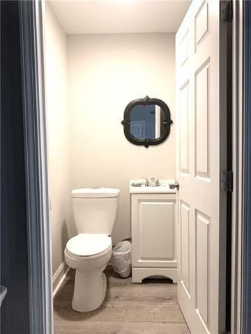 bathroom featuring toilet, a sink, and wood finished floors