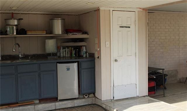 bar featuring refrigerator, wooden ceiling, and a sink