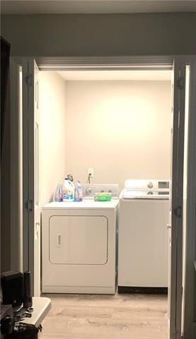 laundry area featuring light wood finished floors and washer and dryer