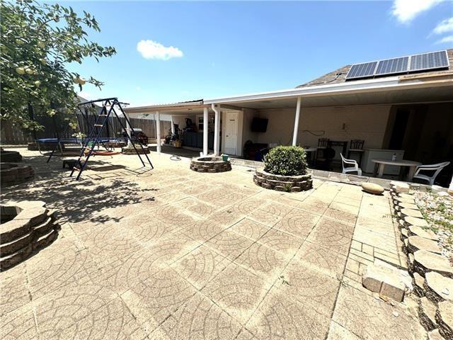 view of patio / terrace featuring playground community, central AC unit, a trampoline, and fence