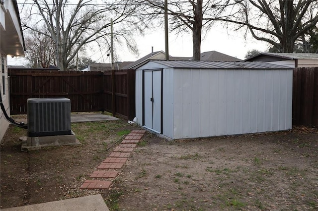 view of yard with a storage unit, central AC unit, an outdoor structure, and a fenced backyard