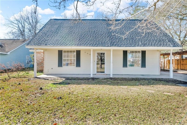 single story home featuring a front yard, roof with shingles, fence, and brick siding