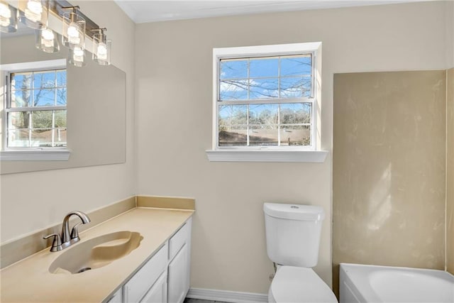 full bath featuring baseboards, vanity, toilet, and a bathing tub