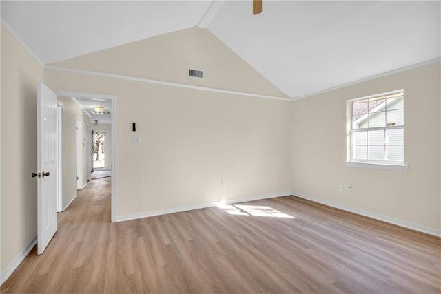 spare room featuring light wood-type flooring, baseboards, visible vents, and vaulted ceiling