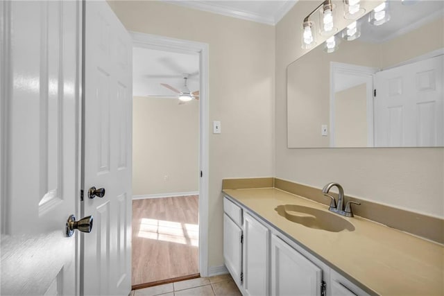 bathroom with ceiling fan, tile patterned flooring, vanity, baseboards, and ornamental molding