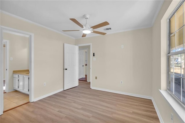 unfurnished bedroom with ornamental molding, light wood-type flooring, and baseboards