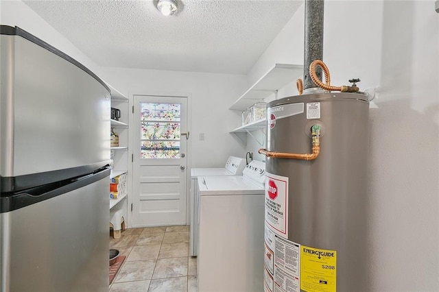 laundry room featuring a textured ceiling, gas water heater, washing machine and dryer, light tile patterned flooring, and laundry area