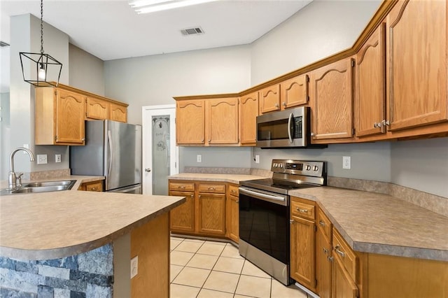 kitchen featuring appliances with stainless steel finishes, pendant lighting, light countertops, and a sink