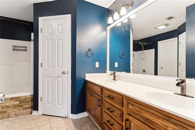 full bath featuring double vanity, visible vents, a sink, and tile patterned floors