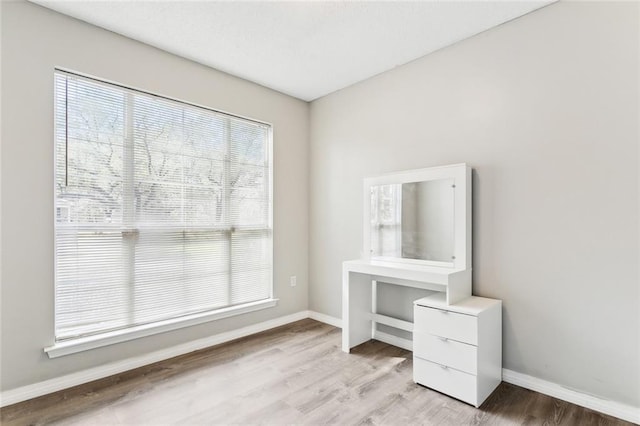 unfurnished office featuring light wood-style flooring and baseboards