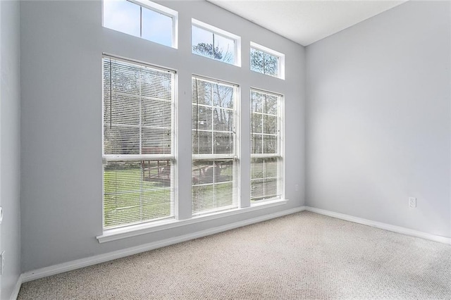 carpeted empty room featuring baseboards