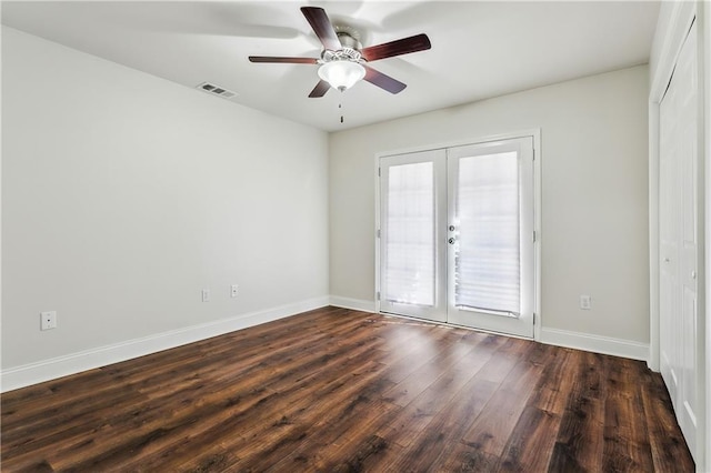 empty room featuring baseboards, visible vents, a ceiling fan, dark wood-type flooring, and french doors