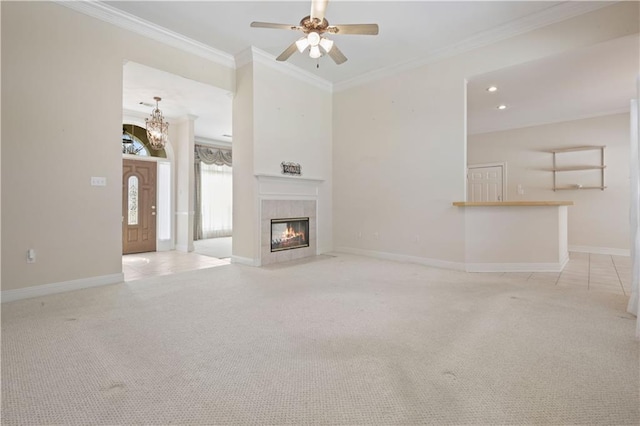 unfurnished living room with baseboards, a ceiling fan, a tile fireplace, light colored carpet, and crown molding