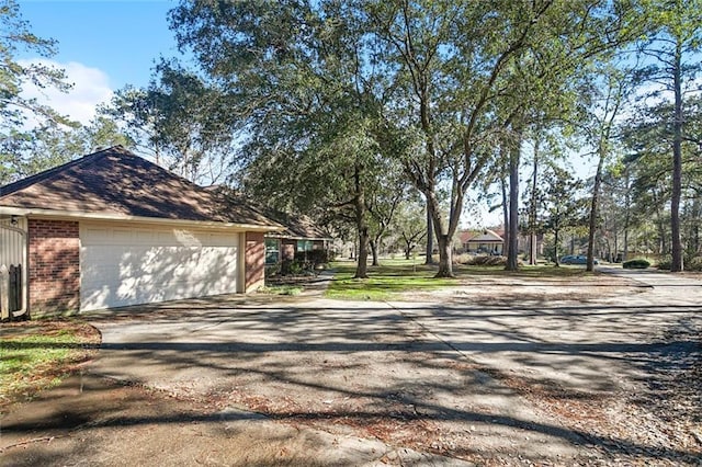 view of home's exterior with driveway, an attached garage, and brick siding