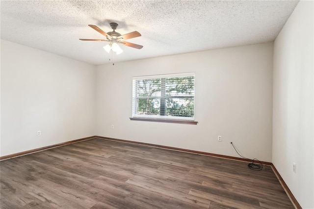 spare room featuring ceiling fan, a textured ceiling, baseboards, and dark wood-type flooring