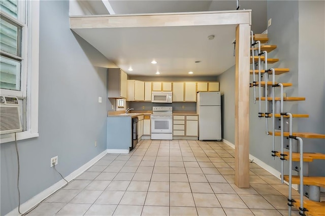 kitchen with light tile patterned floors, white appliances, a sink, baseboards, and light countertops