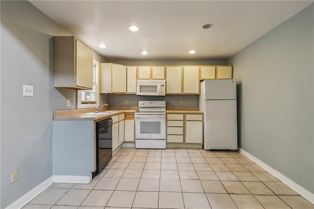 kitchen featuring white appliances, baseboards, light countertops, and a sink