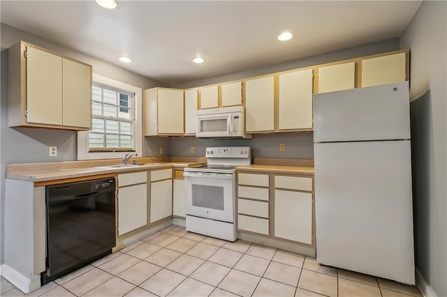 kitchen with cream cabinets, recessed lighting, white appliances, a sink, and light countertops