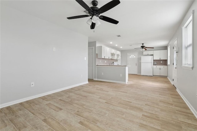 unfurnished living room featuring light wood-style floors, baseboards, a ceiling fan, and recessed lighting