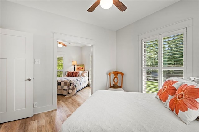 bedroom featuring light wood-style floors, baseboards, and a ceiling fan