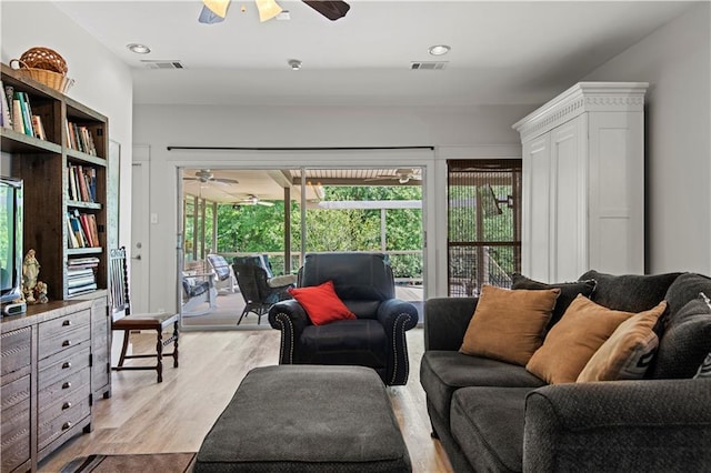 living room featuring visible vents, ceiling fan, and light wood finished floors