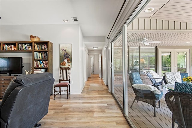 interior space with light wood-style flooring, visible vents, ceiling fan, and french doors