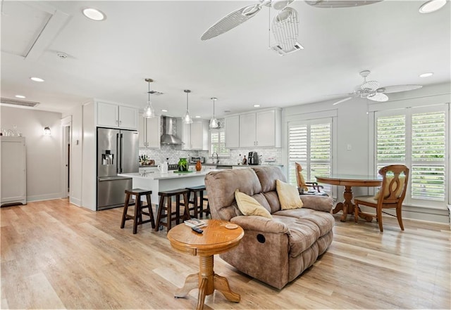 living room featuring recessed lighting, ceiling fan, and light wood-style flooring