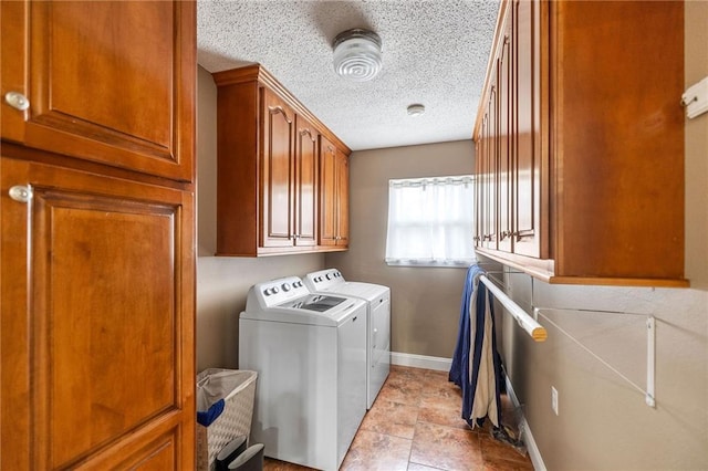 laundry area featuring cabinet space, a textured ceiling, baseboards, and washer and dryer