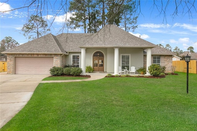 view of front of home with a garage, a shingled roof, concrete driveway, fence, and a front yard