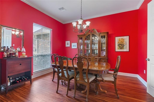 dining area featuring crown molding, visible vents, a notable chandelier, and wood finished floors