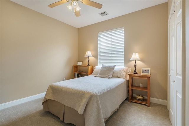 bedroom with baseboards, visible vents, a ceiling fan, and light colored carpet