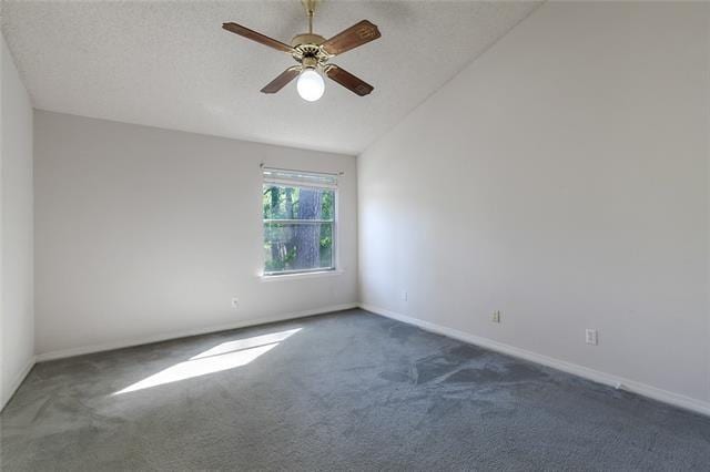 spare room with a ceiling fan, dark carpet, and a textured ceiling