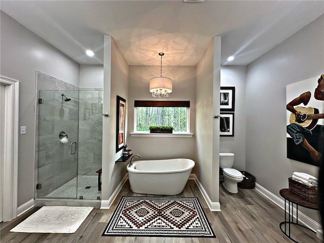 full bathroom with a freestanding tub, a stall shower, wood finished floors, and baseboards