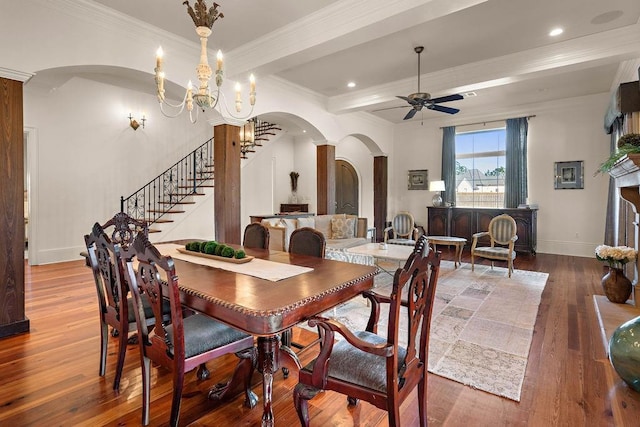 dining area with arched walkways, baseboards, wood-type flooring, stairs, and crown molding