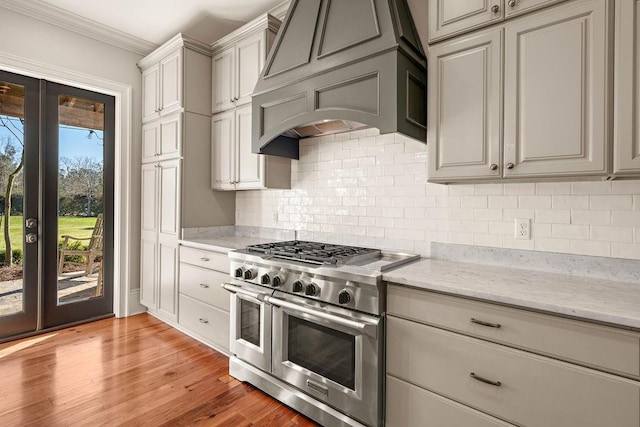 kitchen featuring range with two ovens, gray cabinets, premium range hood, and light wood finished floors