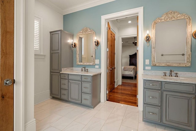 bathroom with ensuite bathroom, two vanities, a sink, and crown molding