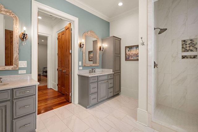 full bathroom featuring a walk in shower, two vanities, a sink, and crown molding