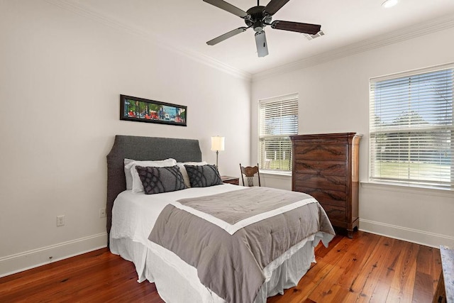 bedroom with wood-type flooring, visible vents, ornamental molding, and baseboards