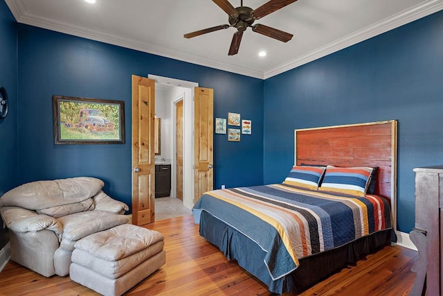 bedroom with recessed lighting, baseboards, light wood-style floors, ornamental molding, and ensuite bath