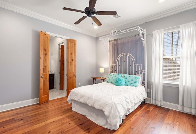 bedroom featuring visible vents, crown molding, baseboards, and hardwood / wood-style flooring